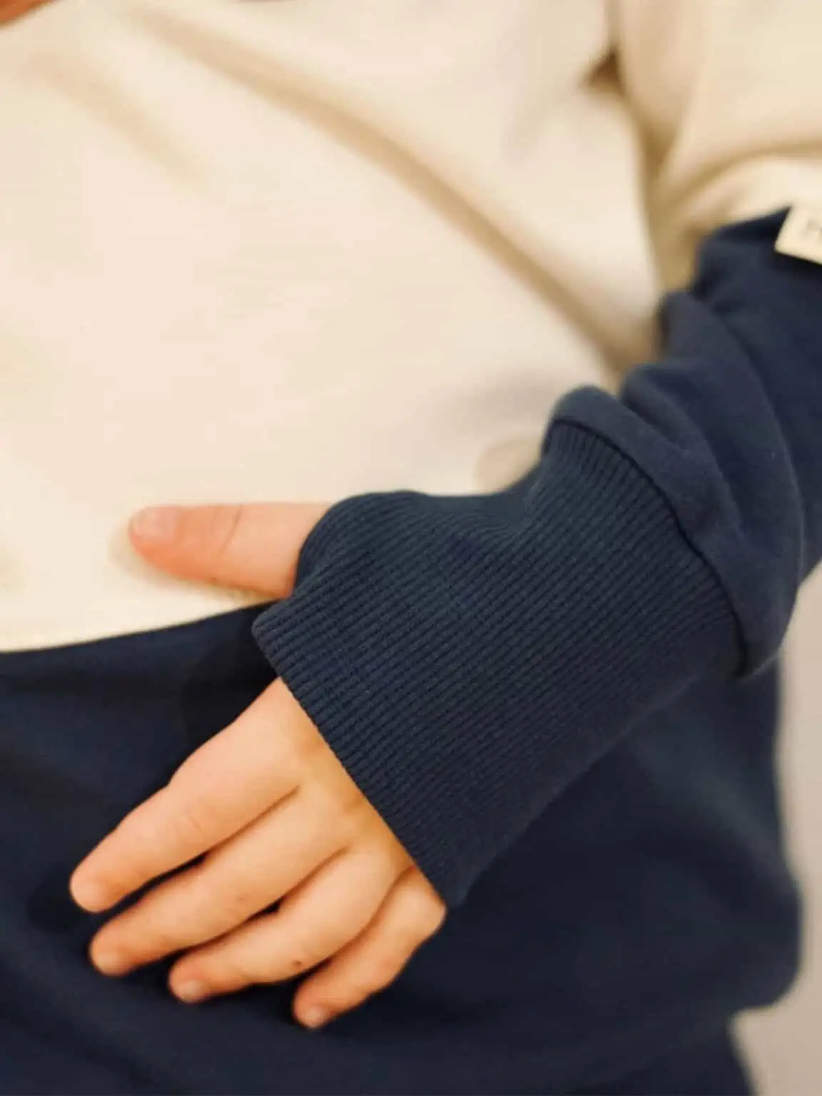 Cremefarbener Raglan Hoodie mit dunkelblauem Daumenlochbündchen