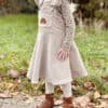 Mädchen im beigen Latzkleid, genäht nach dem Schnittmuster "Twirly Latz" von Schleiferlwerk
