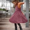 Mädchen dreht sich im Kreis mit dunkelrotem Latzkleid genäht nach dem Schnittmuster "Twirly Latz" von Schleiferlwerk