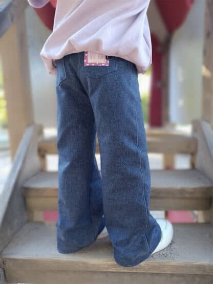 Selbst genähte Baggy Hose in Jeansoptik mit Po-Tasche und Label auf einer Spielturmtreppe.