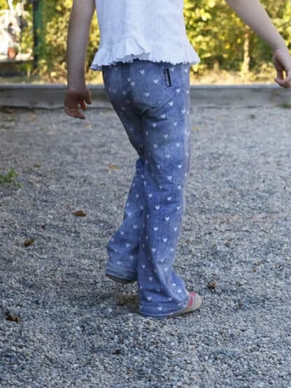 Blaue weite Hose mit kleinem weißem Muster beim Gehen über Kies.