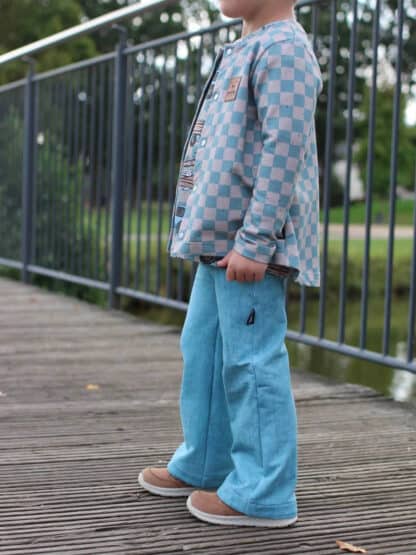 Hellblaue Baggy Hose mit karierter Jacke auf einer Holzbrücke, genäht nach dem Schnittmuster Wide Legs.