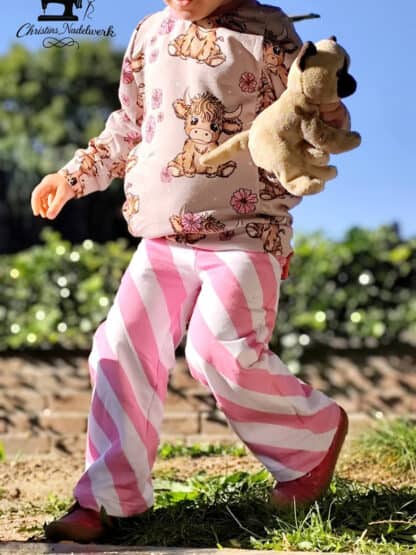 Rosa-weiß gestreifte Baggy Hose, selbst genäht, mit Kuscheltier im Arm beim großen Schritt.