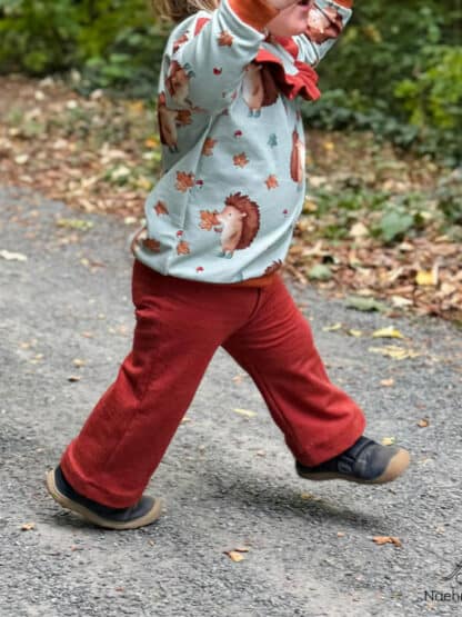 Rostrote weite Jogginghose am laufenden Kleinkind, genäht nach dem Schnittmuster Wide Legs.