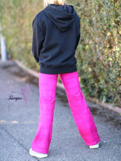 Pinke weite Hose von hinten mit schwarzem Hoodie auf einem Weg.
