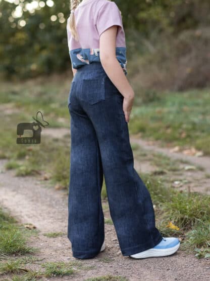 Dunkelblaue weite Hose in Jeansoptik mit Po-Tasche, seitlich auf einem Feldweg.