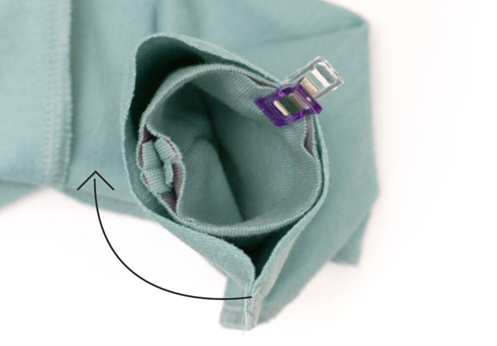 Daumenlochbündchen wird versetzt zur Ärmelnaht an den Hoodie-Ärmel gesteckt